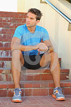 Fitness, break and man athlete on stairs in the city training for race, marathon or competition. Sports, exercise and