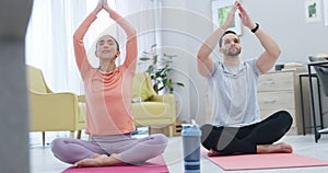 Fitness, breathing and couple doing yoga in the living room together for body, mind and spiritual wellness. Calm