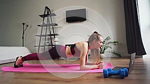 Fitness caucasian woman doing plank exercise workout in gym indoors home on the mat and very tired