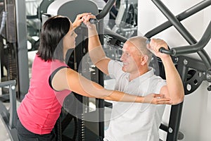 Fitness center trainer assist man exercise back