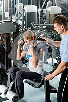 Fitness center young woman exercise with trainer