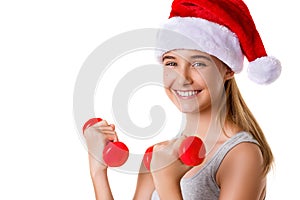 Fitness christmas young girl training lifting hand weight wearing santa hat,isolated