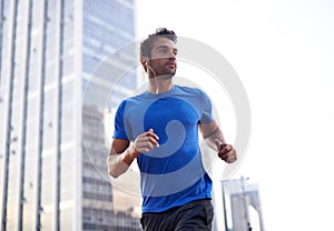 Fitness, city and male athlete running for health, wellness or training for a marathon, competition or race. Sports
