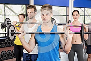 Fitness class lifting barbell