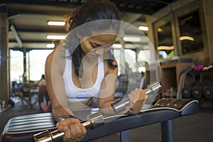 Fitness club lifestyle portrait of young attractive and happy athletic Asian Indonesian woman training at gym lifting weight
