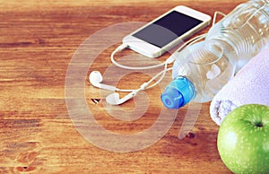 Fitness concept with bottle of water, mobile phone with earphones