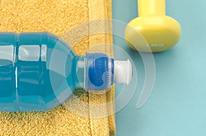 Fitness concept with dumbbell, towel and bottle/yellow dumbbell