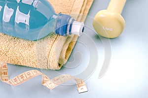 Fitness concept with dumbbells, towel, measure tape and bottle