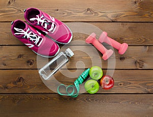 Fitness Concept with Fruits, Bottle of Water, Sport Equipment on Wooden Textured Background Top View
