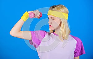 Fitness concept. Girl exercising with dumbbell. Fitness instructor hold little dumbbell blue background. How to get