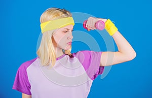 Fitness concept. Girl exercising with dumbbell. Fitness instructor hold little dumbbell blue background. How to get