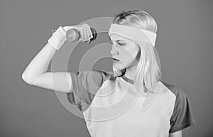 Fitness concept. Girl exercising with dumbbell. Fitness instructor hold little dumbbell blue background. How to get