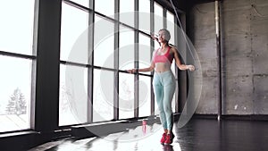 Fitness concept. Healthy lifestyle. Young slim woman jumping with skipping rope in gym. 20s 4k