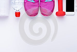 Fitness concept with mobile phone with towel and woman sport footwear over white background