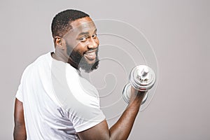 Fitness concept. Portrait of a happy african american black man with dumbbells isolated over grey background