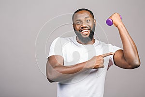 Fitness concept. Portrait of a happy african american black man with dumbbells isolated over grey background