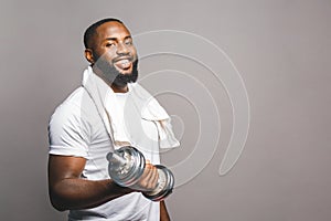 Fitness concept. Portrait of a happy african american black man with dumbbells isolated over grey background