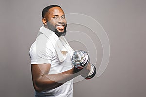 Fitness concept. Portrait of a happy african american black man with dumbbells isolated over grey background