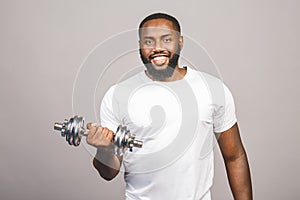 Fitness concept. Portrait of a happy african american black man with dumbbells isolated over grey background