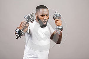 Fitness concept. Portrait of a happy african american black man with dumbbells isolated over grey background