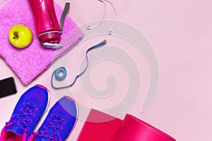 Fitness concept with Ultra violet pink female sneakers, water bottle, yoga mat, towel, smartphone, headphones, apple on pastel pin