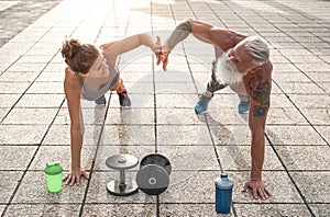 Fitness couple doing push ups exercise outdoor - Happy athletes making workout session outside