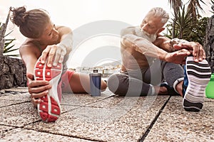 Fitness couple doing stretching exercise outdoor - Happy athletes making workout session at sunset outside