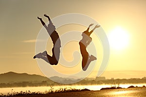 Fitness couple jumping happy at sunset