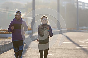 Fitness couple running in the town in the morning