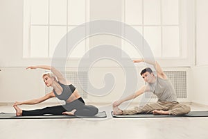 Fitness couple stretching at white background