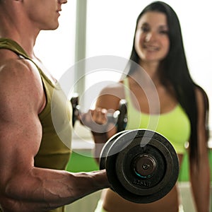 Fitness couple workout - fit man and woman train in gym