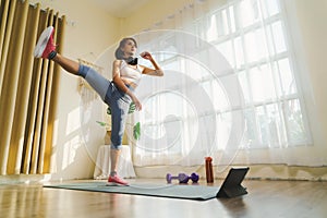 Fitness course at home with Technology tablet online, Asian female in sportswear and sneakers exercising indoors to burn fat doing