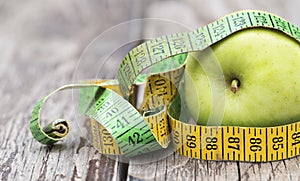 Fitness, diet concept - green apple with tape measure, web banner