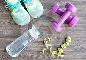 Fitness equipment, Dumbbell shoes, water bottles on wooden floor.Health and Fitness Concepts