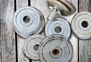 Fitness equipment dumbbell weights on old wood background