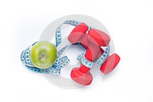 Fitness equipment. Healthy food. Apple, dumbbells and measuring tape on white background. View from above