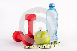 Fitness Essentials: Red Dumbbell, Measuring Tape, Green Apple, and Water Bottle