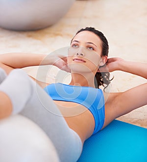 Fitness, exercise ball and pushup by woman on a gym floor for training, wellness and routine. Pilates, workout and