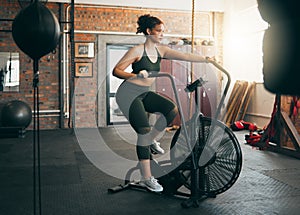 Fitness, exercise bike and woman at gym for workout, cardio training and cycling for energy, balance and lose weight