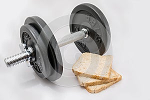 Fitness exercise equipment dumbbell weights and three fresh bread slices