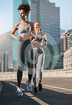 Fitness, exercise and friends running in the city together for an intense cardio workout in street. Sports, athletes and