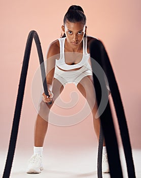 Fitness, exercise and woman doing battle ropes workout in her healthy training routine in a sports studio. Girl, energy