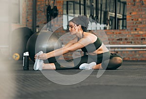 Fitness, exercise and a woman stretching at gym during warm up workout and training for health and wellness. Sports