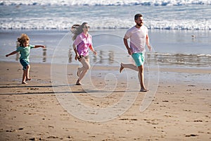 Fitness family running on the beach. Happy mother father with child son, having fun during summer holiday. Family