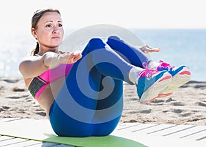 Fitness female stretching muscles on the sand