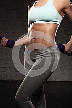 Fitness female woman with muscular body, do her workout with dumbbells, abs, abdominals