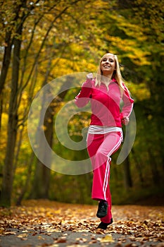 Fitness fit woman blond girl doing exercise in autumnal park. Sport.