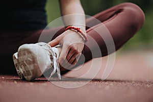 Fitness-focused individual tying a shoe on a track, ready for exercise