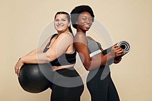 Fitness Friends. Slim And Plus Size Models. Diversity Women In Black Sportswear Holding Fitness Ball And Mat.