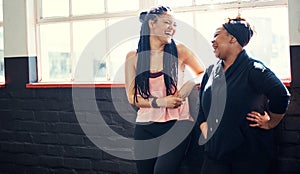 Fitness friends. two cheerful young women having a conversation before a workout session in a gym.